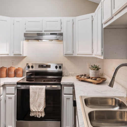 kitchen at Jamestown Landing Apartments featuring vaulted ceilings, a skylight, stainless steel appliances, and wood-style flooring.