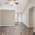 Room with wood floors can see the kitchen in the back of the room