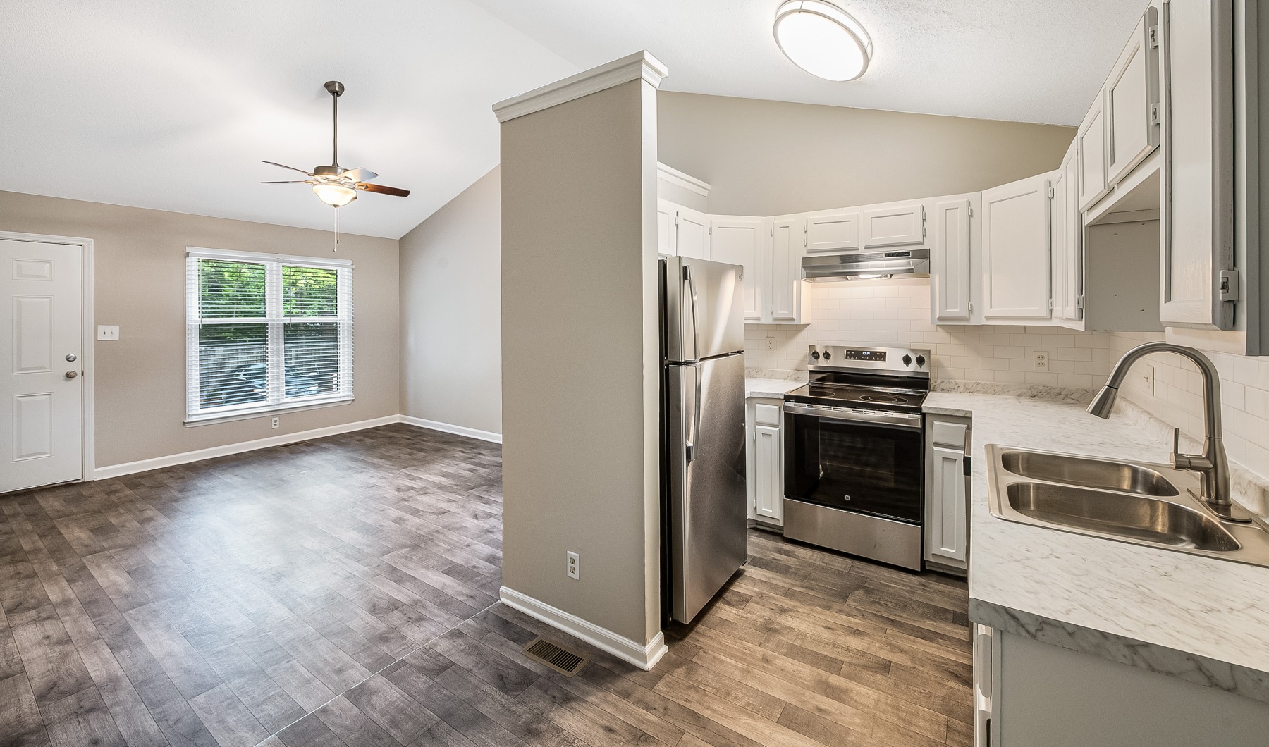 Spacious and well lit kitchen with wood floors and granite countertops
