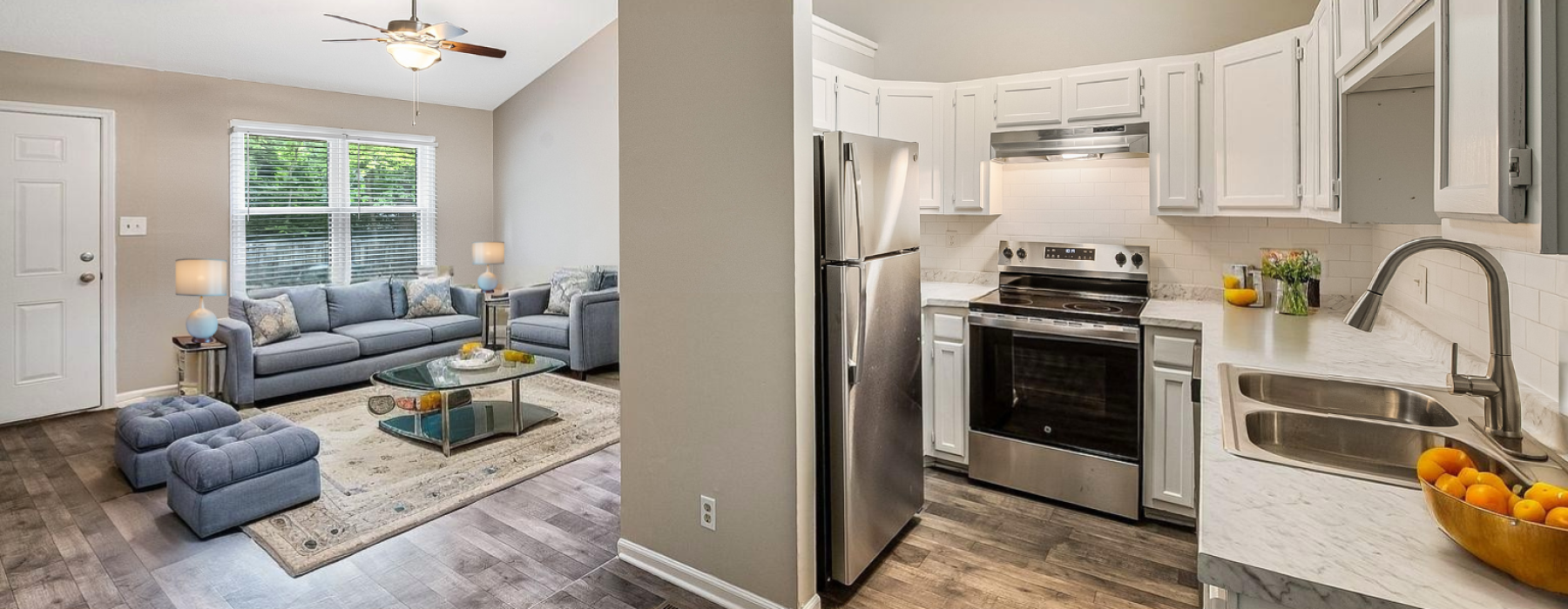 Renovated kitchen with view into living room with couch and table
