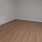 Spacious and well lit living room with wood floors and an open floor plan with access to the kitchen.