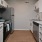 Spacious and well lit kitchen with wood floors and stainless steel appliances. 