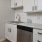 Spacious and well lit kitchen with wood floors and stainless steel appliances. 