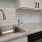 Spacious and well lit kitchen with wood floors and stainless steel appliances. 