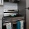 Spacious and well lit kitchen with wood floors and stainless steel appliances. 